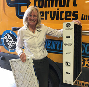 Debbie, Comfort Consultant at All Comfort Services, holding air filters