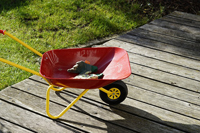Photo of a red wheel barrow on a back porch