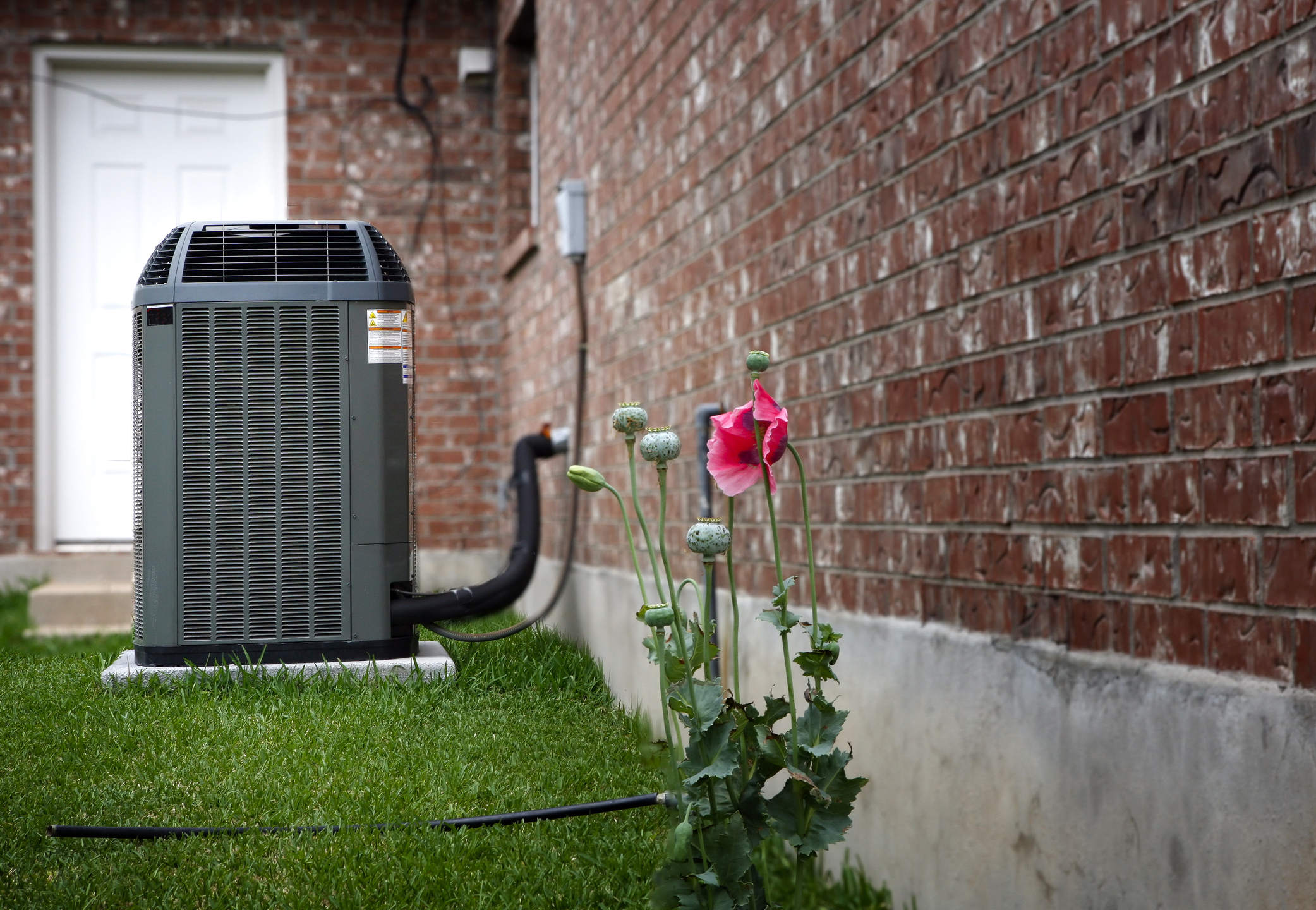 High efficiency HVAC system in background; brick home in background.